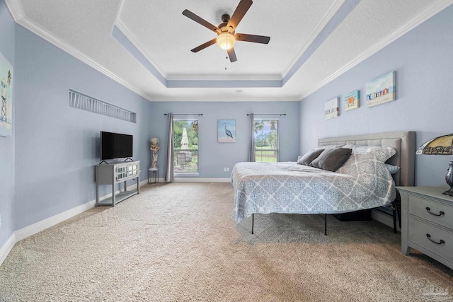 bedroom with a textured ceiling, ornamental molding, a tray ceiling, ceiling fan, and carpet