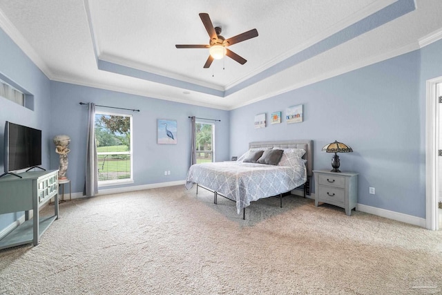 bedroom with crown molding, a tray ceiling, a textured ceiling, and carpet