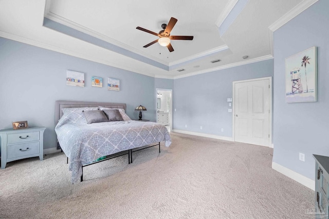 carpeted bedroom featuring ceiling fan, ornamental molding, a tray ceiling, and connected bathroom