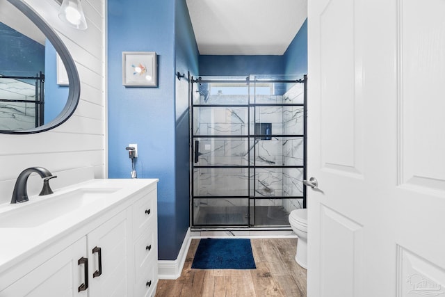 bathroom featuring hardwood / wood-style flooring, vanity, toilet, and a shower with door