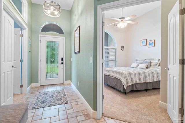 bedroom featuring a towering ceiling and ceiling fan with notable chandelier