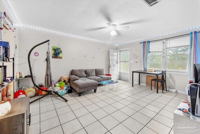 tiled living room with a textured ceiling and ceiling fan