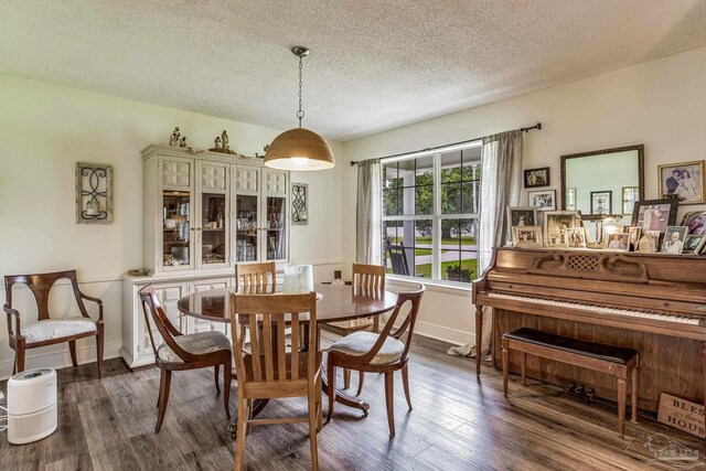 kitchen with kitchen peninsula, appliances with stainless steel finishes, wood-type flooring, white cabinetry, and a breakfast bar area