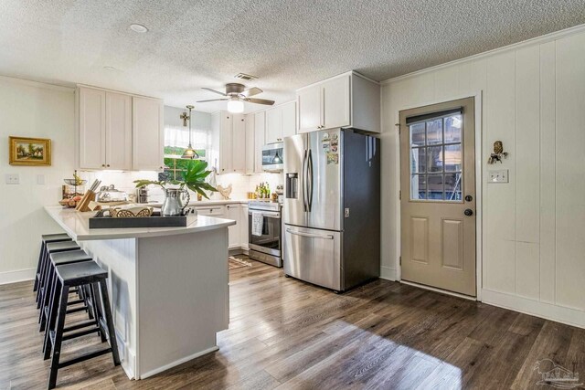 kitchen with white cabinetry, crown molding, a textured ceiling, and appliances with stainless steel finishes