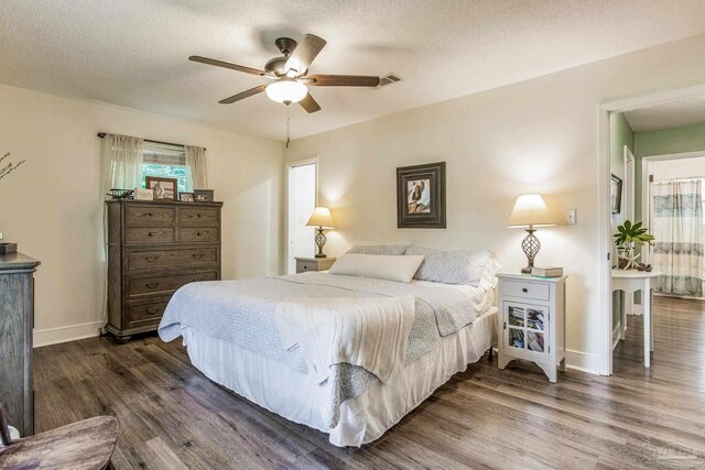 bedroom with hardwood / wood-style flooring, ceiling fan, a textured ceiling, and multiple closets