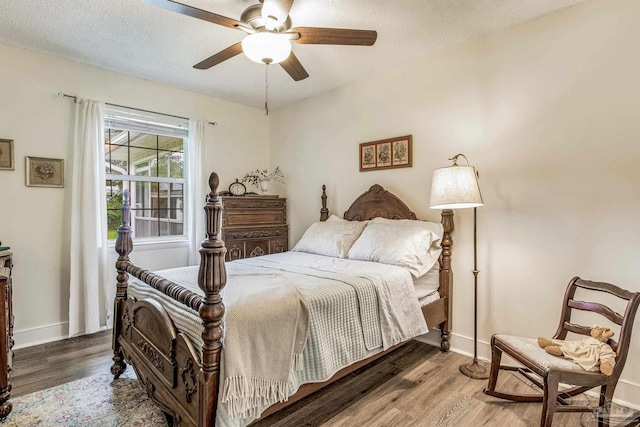 bedroom featuring a textured ceiling, ceiling fan, and dark hardwood / wood-style floors