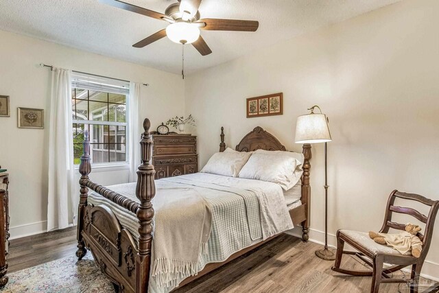 bedroom featuring a textured ceiling, ceiling fan, dark wood-type flooring, and a closet