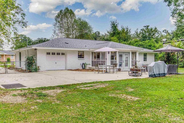 back of house featuring central air condition unit, a sunroom, and a lawn