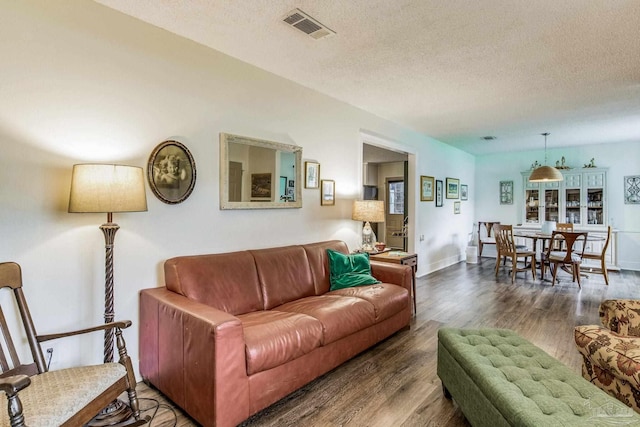 living room featuring a textured ceiling and dark wood-type flooring