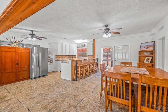 dining space with a textured ceiling and ceiling fan