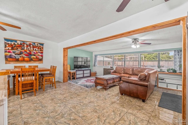 living room with ceiling fan, a textured ceiling, and lofted ceiling