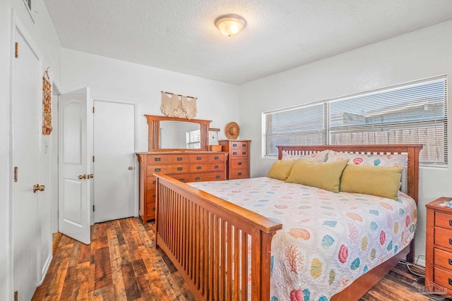 bedroom featuring a textured ceiling and dark hardwood / wood-style floors