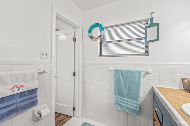 bathroom with tile walls, vanity, and hardwood / wood-style flooring