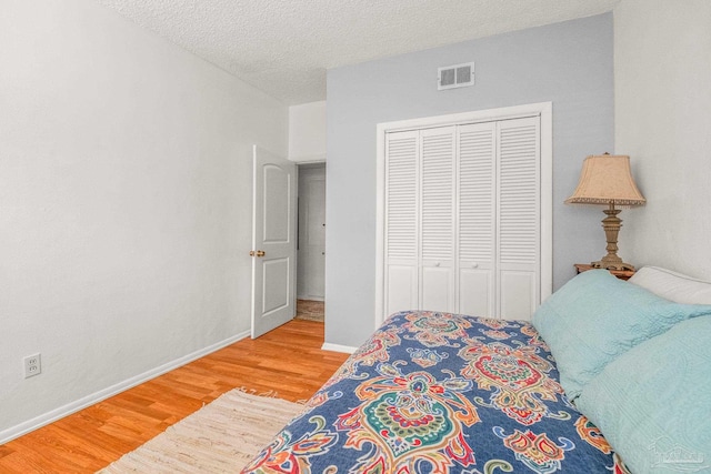 bedroom featuring a textured ceiling, hardwood / wood-style flooring, and a closet