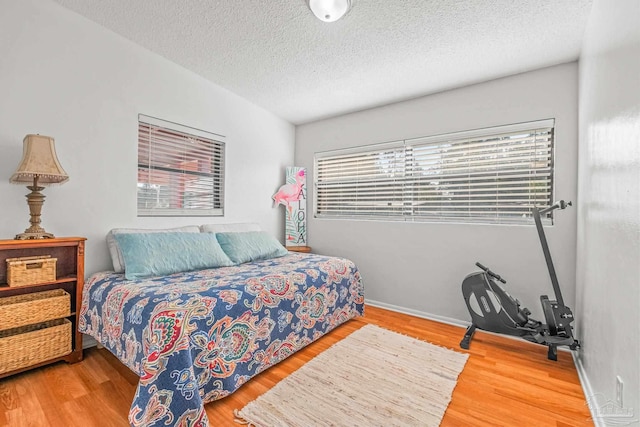 bedroom featuring a textured ceiling and wood-type flooring