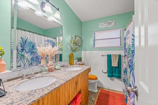 bathroom featuring vanity, toilet, and tile walls