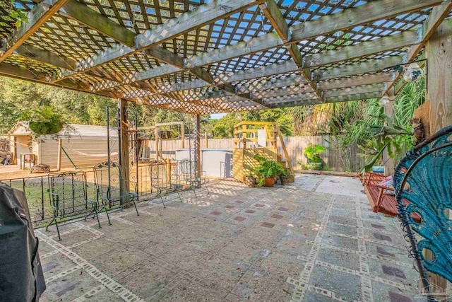 view of patio / terrace with a pergola and a storage unit