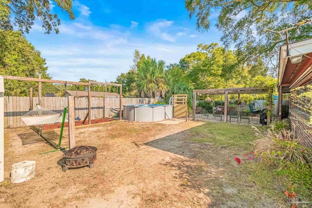 view of yard with a fenced in pool and a fire pit