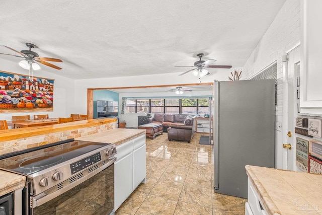 kitchen featuring a textured ceiling, white cabinetry, and stainless steel appliances