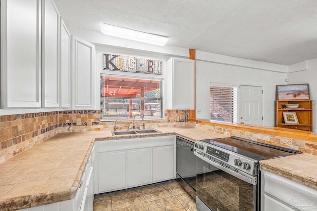 kitchen featuring white cabinets, backsplash, appliances with stainless steel finishes, a textured ceiling, and sink