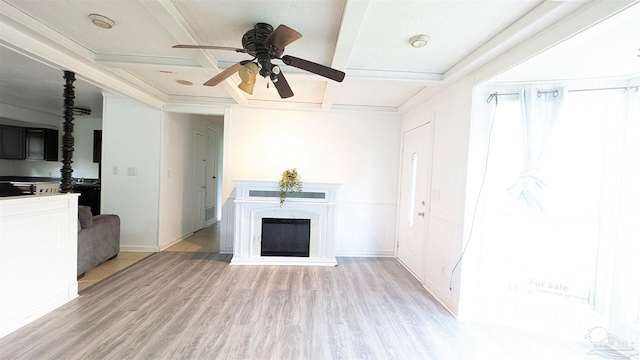 unfurnished living room with light hardwood / wood-style floors, beam ceiling, ceiling fan, ornamental molding, and a premium fireplace