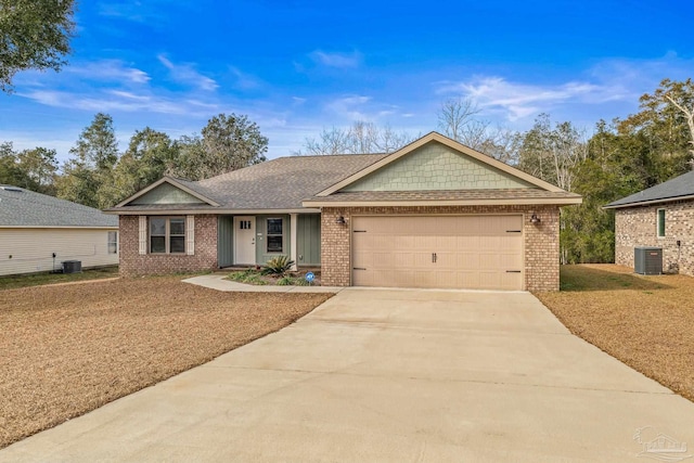 single story home with central AC unit and a garage