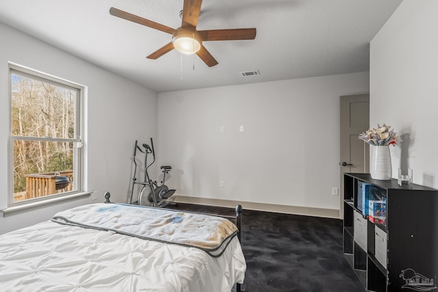 bedroom featuring multiple windows, dark carpet, and ceiling fan