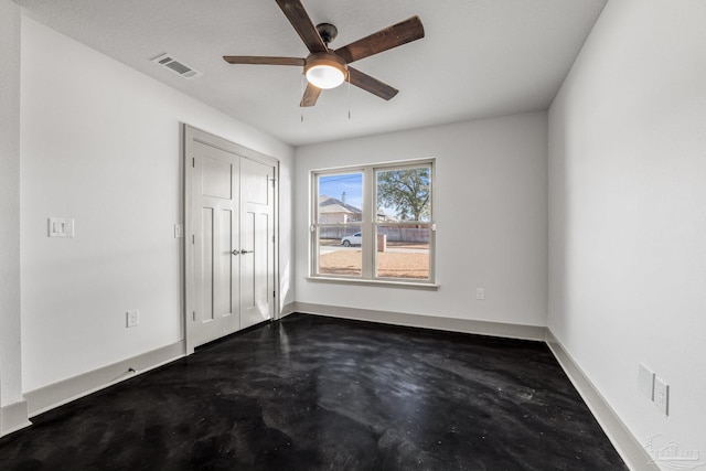 unfurnished bedroom with concrete flooring, a closet, and ceiling fan