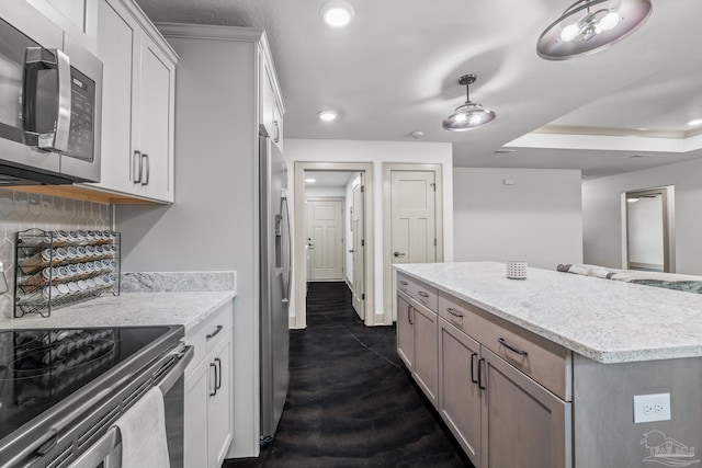 kitchen with white cabinetry, backsplash, light stone counters, stainless steel appliances, and crown molding