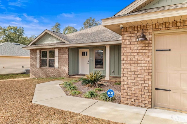 entrance to property featuring a garage and central AC unit