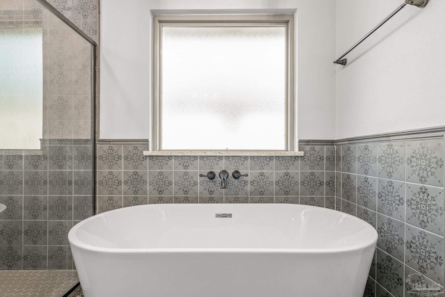 bathroom with tile walls and a bathing tub