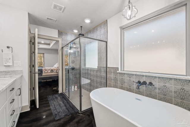 bathroom featuring vanity, hardwood / wood-style floors, plus walk in shower, and a textured ceiling