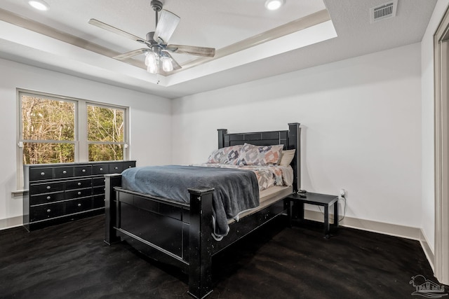 bedroom with a tray ceiling and ceiling fan