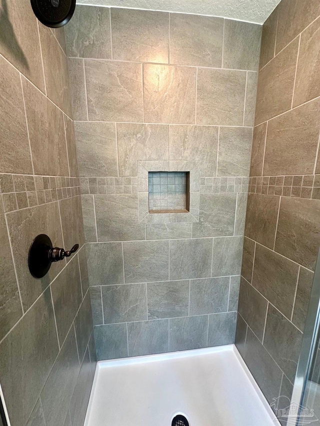 bathroom with a tile shower