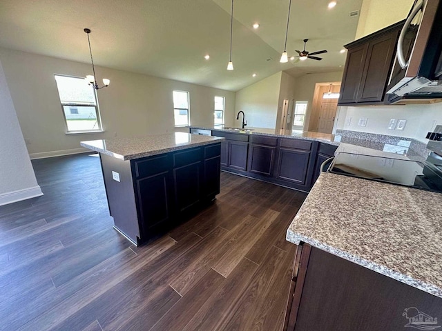 kitchen featuring dark wood-style flooring, a sink, a peninsula, stainless steel appliances, and recessed lighting