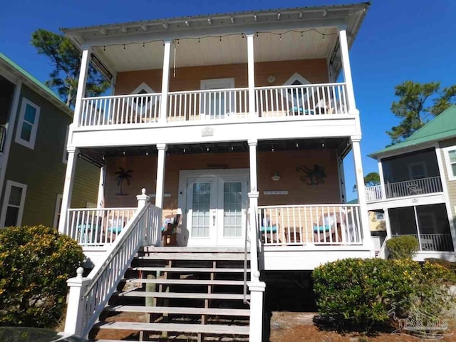 view of front of house featuring covered porch, french doors, and stairway