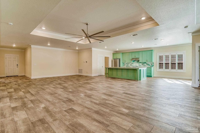 unfurnished living room featuring ceiling fan, light hardwood / wood-style floors, ornamental molding, and a textured ceiling