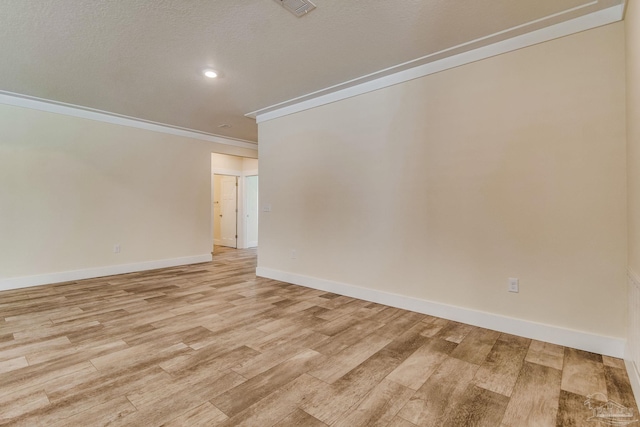 unfurnished room featuring light hardwood / wood-style floors, a textured ceiling, and ornamental molding