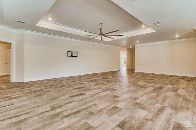 unfurnished room with light hardwood / wood-style floors, a raised ceiling, and ornamental molding