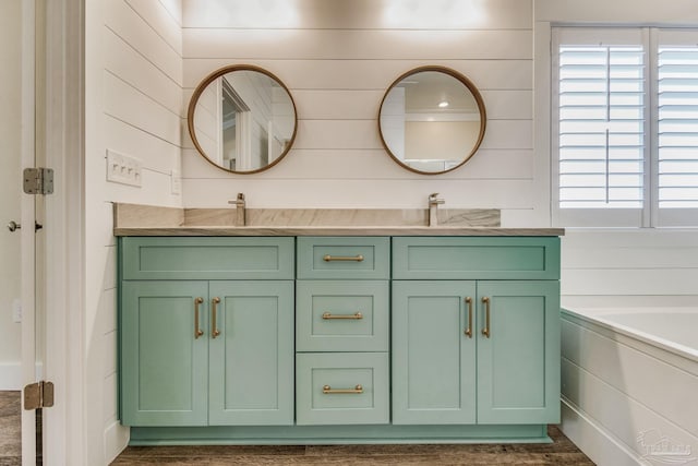 bathroom featuring wooden walls, a bathtub, and vanity