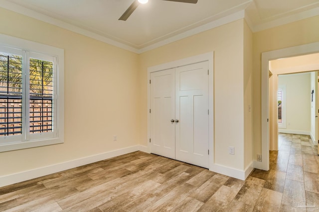 unfurnished bedroom with a closet, light hardwood / wood-style flooring, ceiling fan, and crown molding