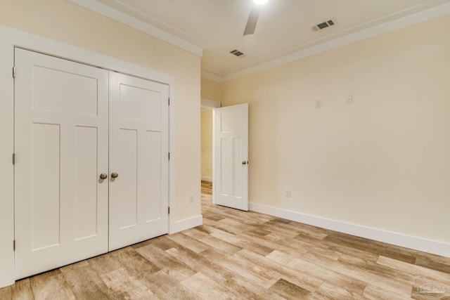 unfurnished bedroom with light wood-type flooring, a closet, ceiling fan, and ornamental molding