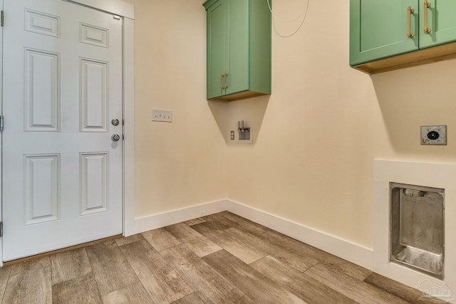 laundry room featuring electric dryer hookup, cabinets, and light hardwood / wood-style floors