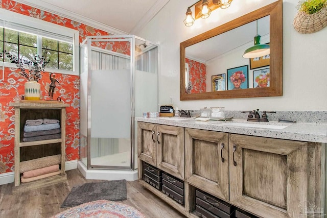 bathroom with double vanity, ornamental molding, hardwood / wood-style flooring, lofted ceiling, and a shower with shower door