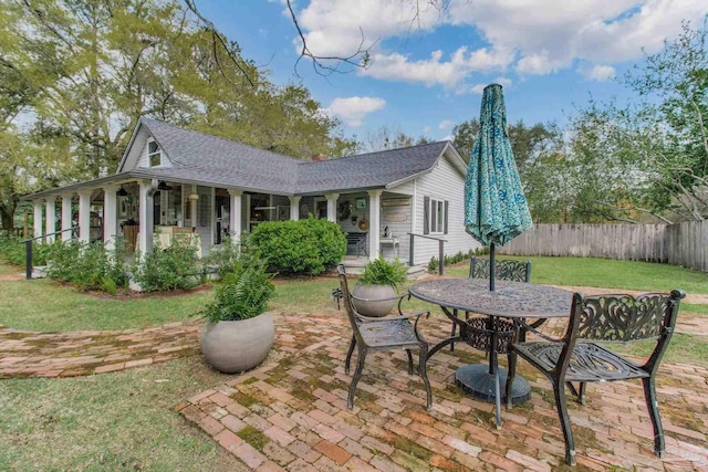 back of house featuring covered porch and a yard