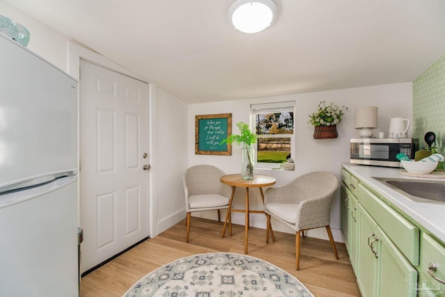 living area featuring sink and light hardwood / wood-style flooring