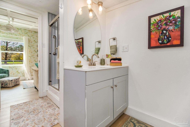 bathroom with wood-type flooring, walk in shower, and vanity