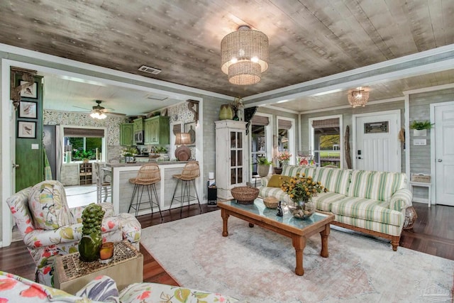 living room featuring dark wood-type flooring and ceiling fan with notable chandelier