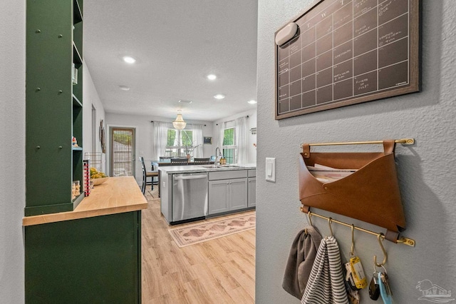 8820 Smiley Ct, Pensacola, FL 32514 - kitchen with stainless steel dishwasher, light wood finished floors, recessed lighting, butcher block countertops, and a textured wall