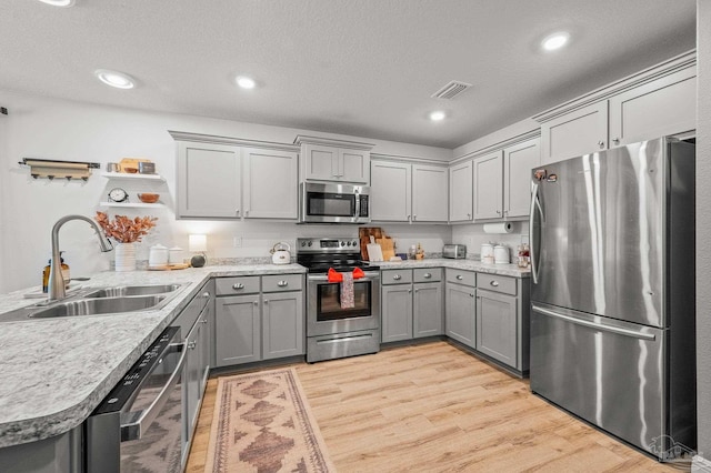 8820 Smiley Ct, Pensacola, FL 32514 - kitchen featuring appliances with stainless steel finishes, gray cabinetry, light wood-style flooring, light countertops, and recessed lighting